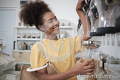 A customer fills cereal foods in a glass jar in a refill retail store Stock Photo