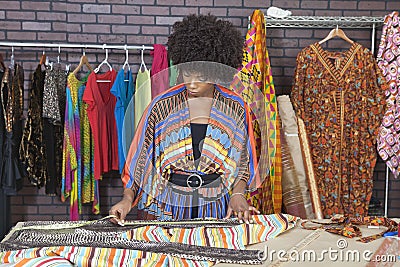 African American female designer measuring cloth at design studio Stock Photo