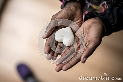 African-American girl hands holding a marble made heart Stock Photo