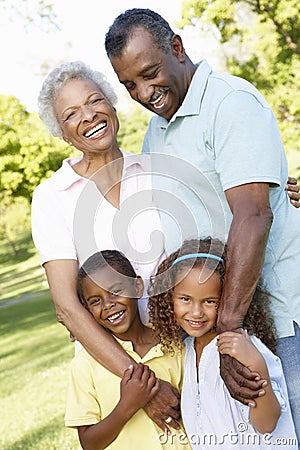 African American Grandparents With Grandchildren Walking In Park Stock Photo