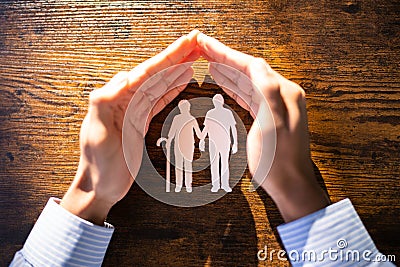 African American Hand Protecting Senior Couple Stock Photo
