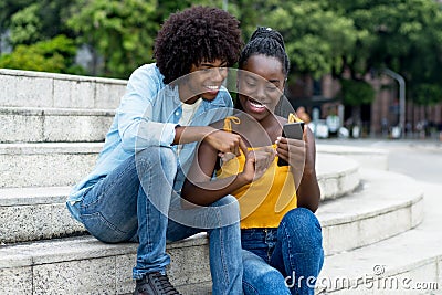 African american influencer posting message with mobile phone Stock Photo