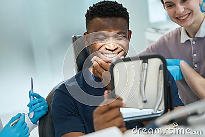 African American male client satisfied with stomatologist work Stock Photo