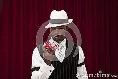 African American male gambler in retro suit holding over size dice Stock Photo