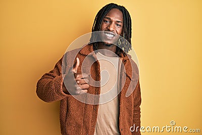 African american man with braids wearing brown retro jacket doing happy thumbs up gesture with hand Stock Photo