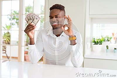 African american man holding fifty dollars bank notes doing ok sign with fingers, excellent symbol Stock Photo