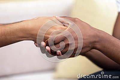 African American man holding hands of beloved woman close up Stock Photo