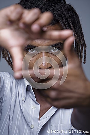 African American man looking through framed hands Stock Photo