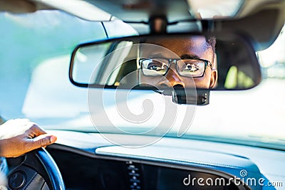 african american man sitting in a car and adjusting rearview mirror looking to back Stock Photo