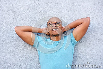 African american man smiling with glasses looking up in contemplation Stock Photo