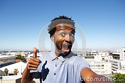 African american man standing by urban background with thumb up Stock Photo