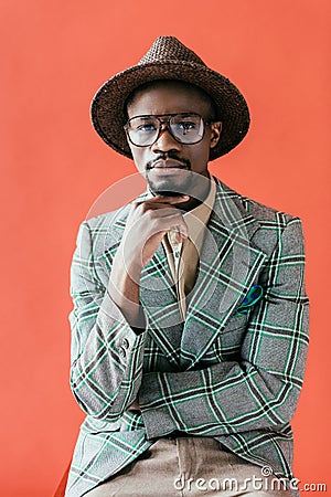 african american man in trendy eyeglasses and hat posing for vintage fashion shoot, Stock Photo