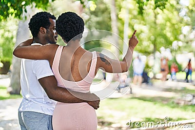 African american man and woman couple hugging each other pointing with finger at park Stock Photo