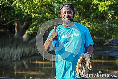 African American men volunteer thumbs up after helpers planting trees in mangrove forest for environmental protection and ecology Stock Photo