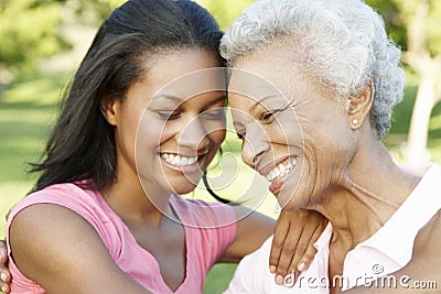 African American Mother And Adult Daughter Relaxing In Park Stock Photo