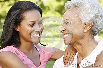 African American Mother And Adult Daughter Relaxing In Park Stock Photo