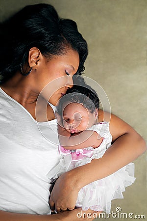 African American Mother Kissing Newborn Daughter Stock Photo