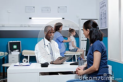 African american pediatrician doctor typing medical symptoms on tablet Stock Photo