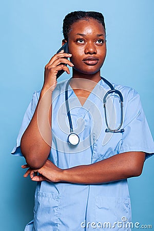 African american physician assistant talking at smartphone discussing disease expertise Stock Photo