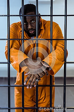 african american prisoner in uniform standing behind Stock Photo