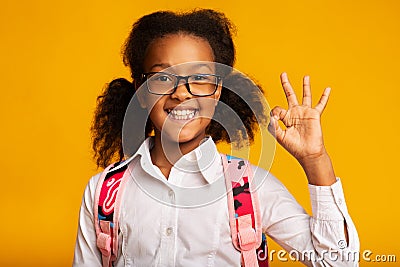 African American Schoolgirl Gesturing Ok Sign Smiling Posing In Studio Stock Photo