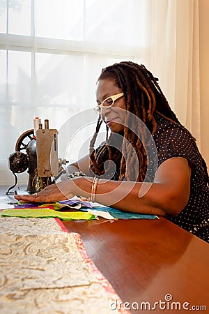 African-American Woman Creates a Quilt on Antique Sewing Machine Stock Photo