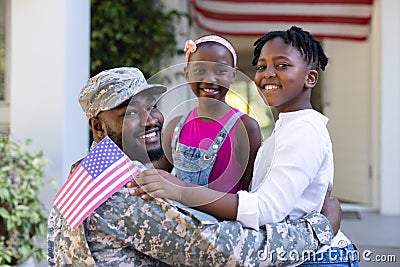 African american soldier father greeting smiling son and daughter in front of house Stock Photo