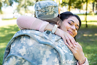 african american soldier in military uniform hugging happy girlfriend Stock Photo