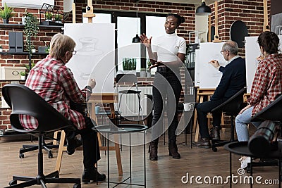 African american teacher giving advice to students explaining sketching technique Stock Photo