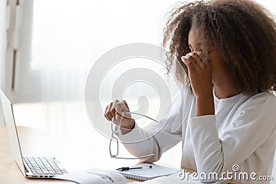 African American teen girl taking off glasses, feeling eye strain Stock Photo