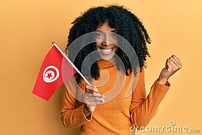 African american woman with afro hair holding turkey flag screaming proud, celebrating victory and success very excited with Stock Photo