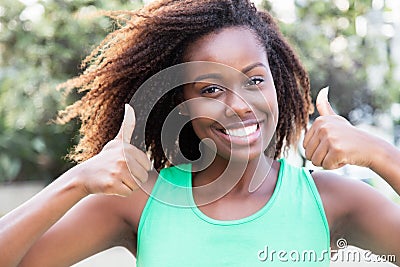 African american woman in a green shirt showing both thumbs Stock Photo