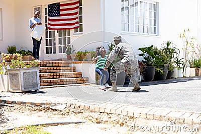 African American woman and her daughter standing welcoming an African American soldier Stock Photo