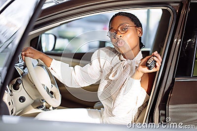 African woman with her new car showing key Stock Photo