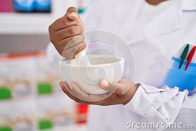 African american woman pharmacist mixing product working at pharmacy Stock Photo
