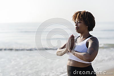 African American woman practicing yoga at the beach Stock Photo