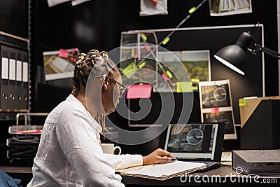 African american private detective studying clues in agency office Stock Photo