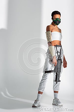 African american woman in safety mask with assault rifle on white background Stock Photo