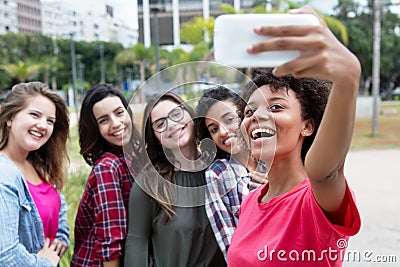 African american woman taking selfie with group of international Stock Photo