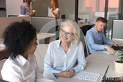 African young manager consulting happy old caucasian client explaining benefits Stock Photo