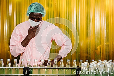 African Black man worker labor working in food and drink industry factory with hygiene work fruit juice production line inspector Stock Photo