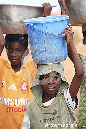 African boys carrying boxes with food on heads Editorial Stock Photo