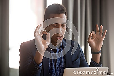 African businessman closed eyes folded fingers reduce stressful situations Stock Photo