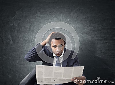 African businessman with newspaper, blackboard Stock Photo