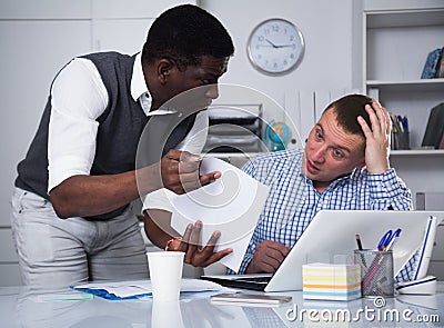 African businessman pointing out mistakes in document Stock Photo