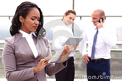 African businesswoman businessman holding a tablet in hand standing outdoor Stock Photo