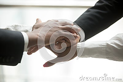 African and caucasian partners put hands together, close up view Stock Photo