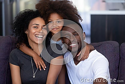 African child daughter embracing young loving black parents, portrait Stock Photo