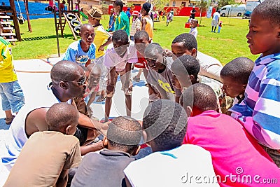 African children doing a sports team huddle on basketball court Editorial Stock Photo
