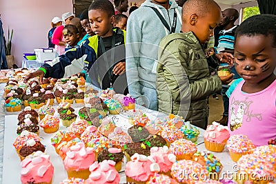 African children receiving cupcakes at Soup Kitchen volunteer community outreach program at orphanage Editorial Stock Photo